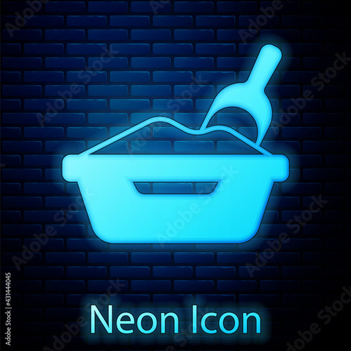 Glowing neon Cat litter tray with shovel icon isolated on brick wall background. Sandbox cat with shovel. Vector