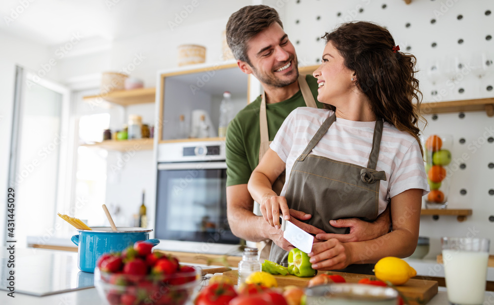Happy young couple have fun in kitchen while preparing healthy organic food Happy young couple have fun in kitchen while preparing healthy organic food