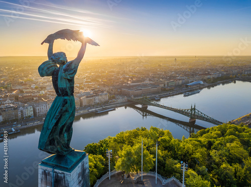 Budapest, Hungary - Aerial view from the top of Gellert Hill with Statue of Liberty, Liberty Bridge and skyline of Budapest at sunrise with clear blue sky photo