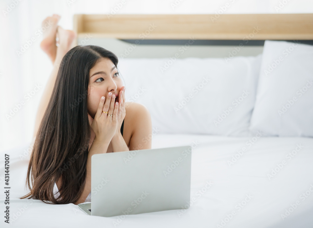 Beautiful young naughty sexy girl with long hair and romantic underwear lie down on bed end and enjoy funny working on laptop in bright morning of rest day Beautiful young naughty sexy girl with long hair and romantic underwear lie down on bed end and enjoy funny working on laptop in bright morning of rest day