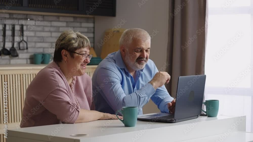 old parents are chatting with children by laptop using video call, elderly man and woman are sitting at kitchen, looking at web camera old parents are chatting with children by laptop using video call, elderly man and woman are sitting at kitchen, looking at web camera
