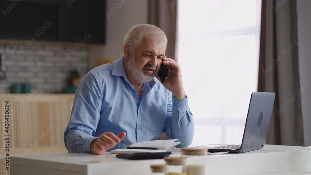 experienced financial consultant is working from home, communicating by phone and calculating, using calculator and laptop, overtime work experienced financial consultant is working from home, communicating by phone and calculating, using calculator and laptop, overtime work