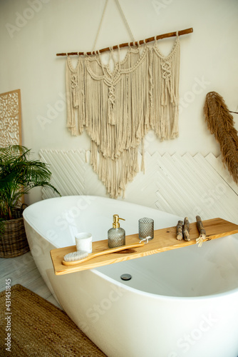 Stylish bathroom interior in boho style. The bathroom has a shelf for brushes, soap and body oils.