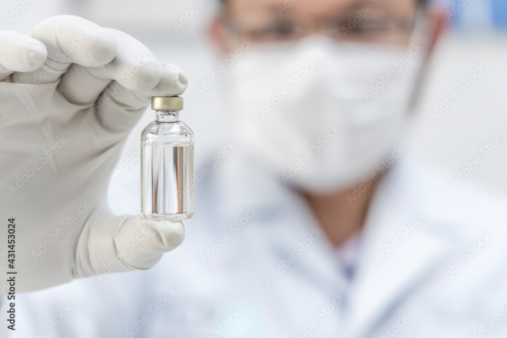 Doctor with white uniform holding vial of COVID-19 vaccine. Healthcare And Medical concept. Doctor with white uniform holding vial of COVID-19 vaccine. Healthcare And Medical concept.
