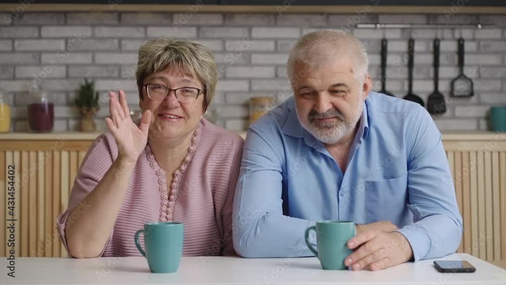 friendly elderly couple of man and woman are looking at camera and smiling, waving hands, portrait shot friendly elderly couple of man and woman are looking at camera and smiling, waving hands, portrait shot