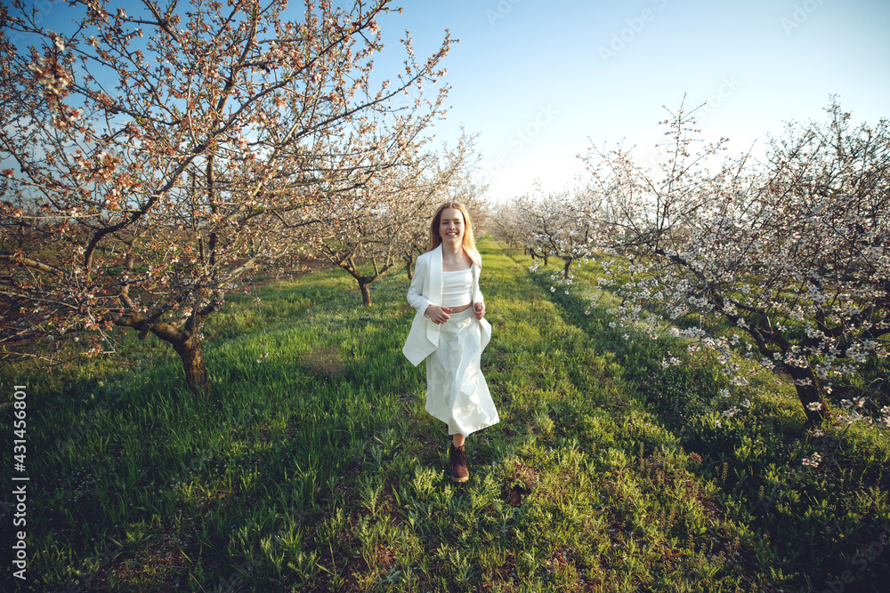 Girl in a blooming garden. A beautiful girl runs in a field with flowers. High quality photo. Girl in a blooming garden. A beautiful girl runs in a field with flowers. High quality photo.