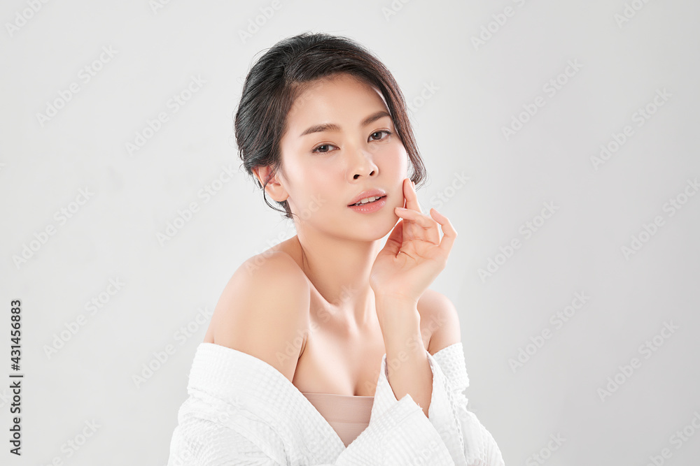 Beautiful young Asian woman wearing bathrobe on white background, Face care, Facial treatment, Cosmetology, beauty and spa Concept. Beautiful young Asian woman wearing bathrobe on white background, Face care, Facial treatment, Cosmetology, beauty and spa Concept.