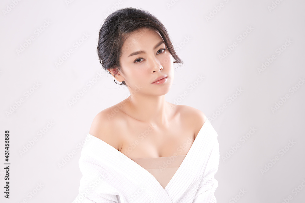 Beautiful young Asian woman wearing bathrobe on white background, Face care, Facial treatment, Cosmetology, beauty and spa Concept. Beautiful young Asian woman wearing bathrobe on white background, Face care, Facial treatment, Cosmetology, beauty and spa Concept.