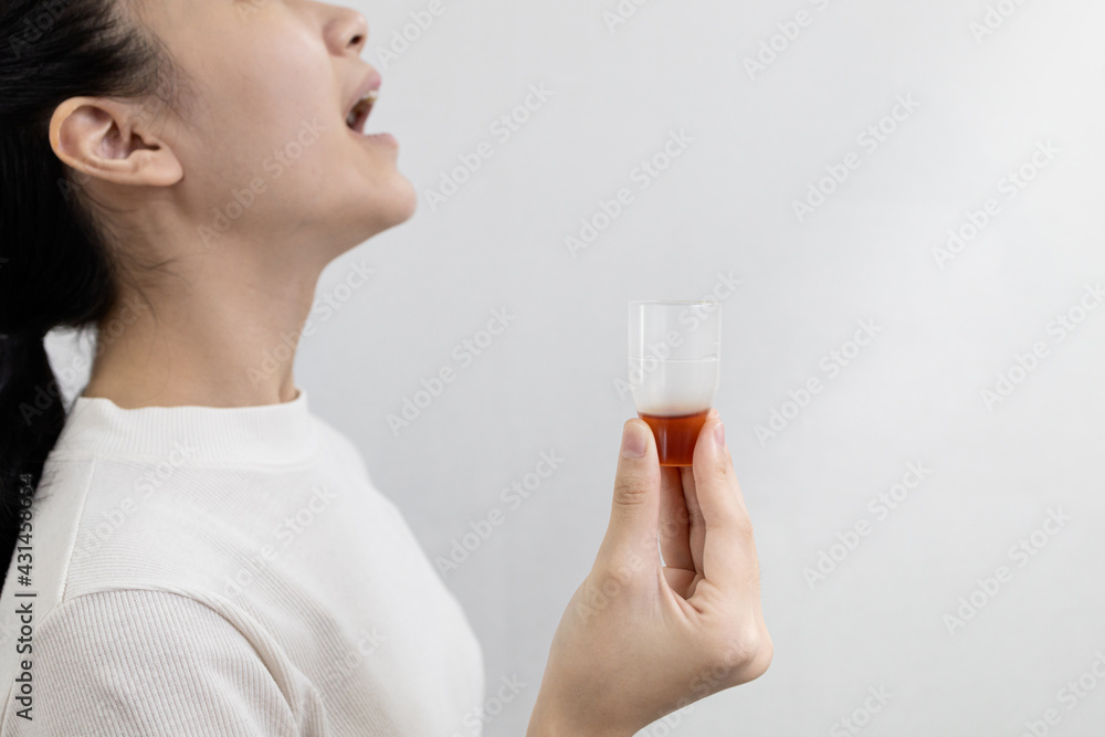 Asian lady girl rinsing the mouth or gargling with medicine of medical disinfectant,protect against the Coronavirus COVID-19 in throat,disinfection of the oral cavity or bad breath,pharyngitis concept Asian lady girl rinsing the mouth or gargling with medicine of medical disinfectant,protect against the Coronavirus COVID-19 in throat,disinfection of the oral cavity or bad breath,pharyngitis concept