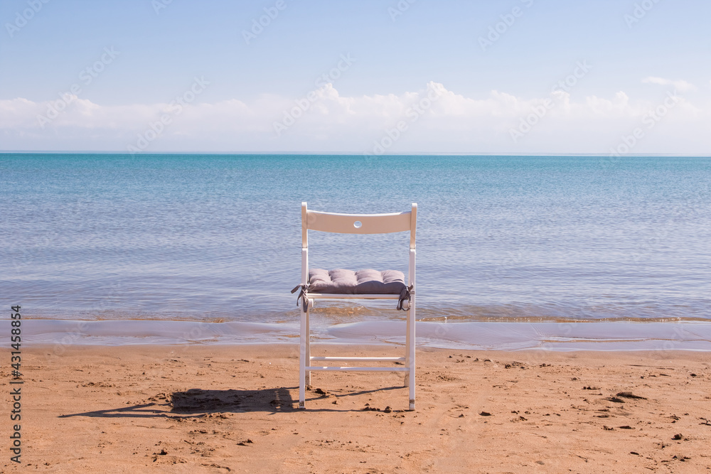 white chair stands on the seashore