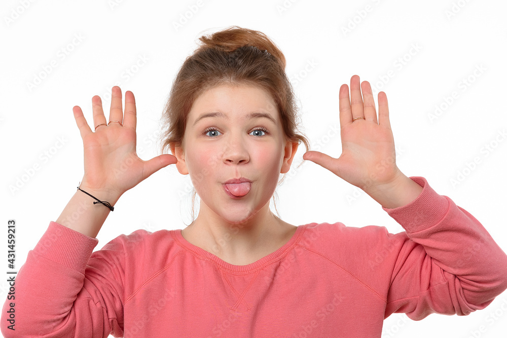 Close-up portrait of cheerful young girl making funny face and showing her tongue. White background Close-up portrait of cheerful young girl making funny face and showing her tongue. White background