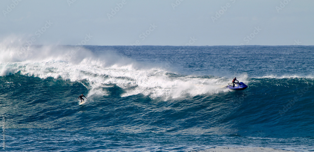 Australian surfer towed by a jetski descending a gigantic wave between the beaches of Bondi and Maroubra south of Sydney Australia.