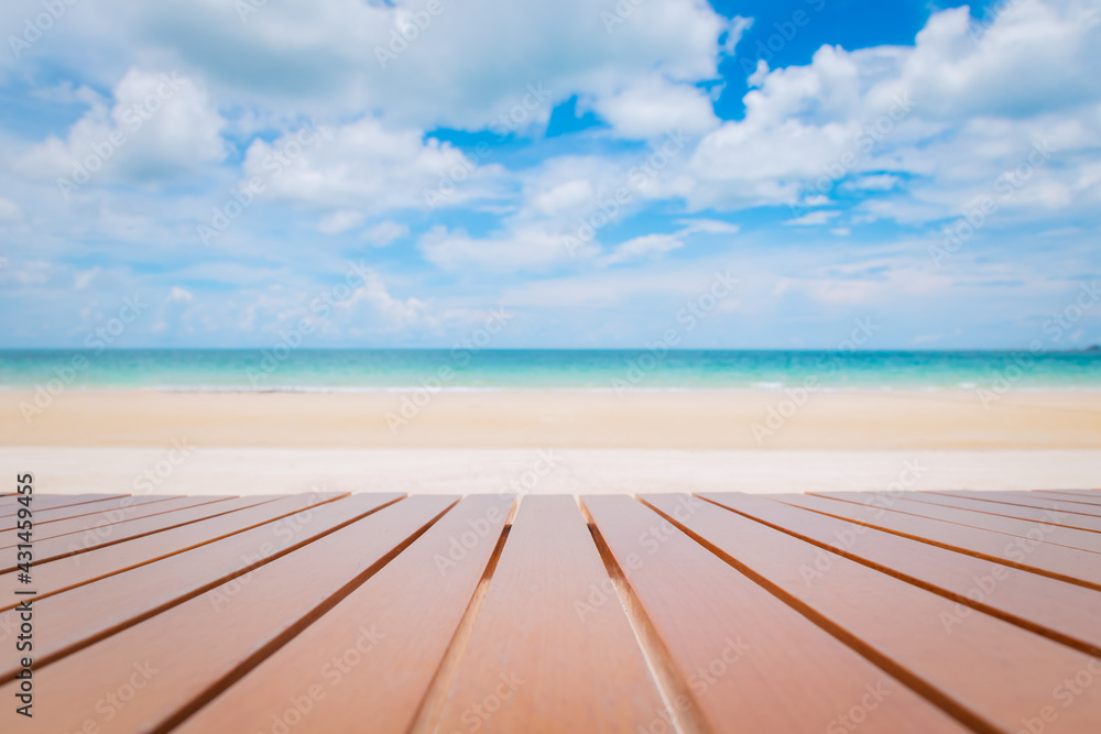 Selective focus of wooden table on tropical beach with 
turquoise sea and blue sky.