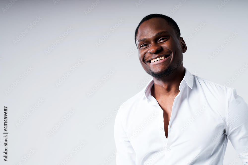 Happy dark-skinned man in white shirt with open collar smiling looking at camera Happy dark-skinned man in white shirt with open collar smiling looking at camera