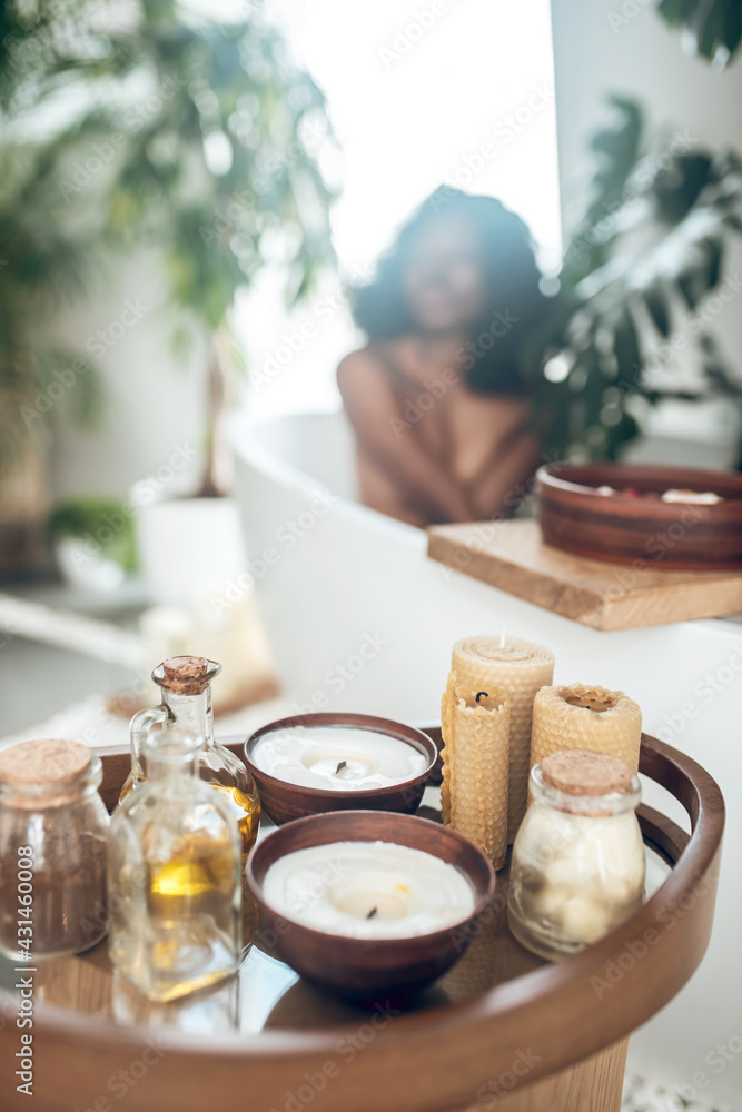 Dark-skinned woman relaxing in a bath and washing her body Dark-skinned woman relaxing in a bath and washing her body