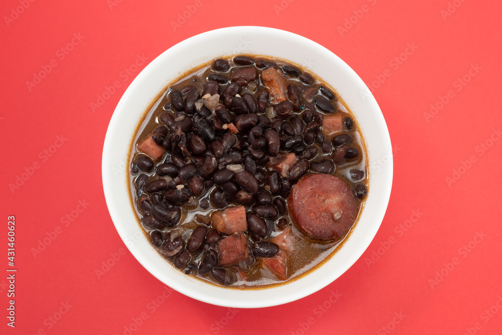 black beans with meat and sausages in white bowl black beans with meat and sausages in white bowl