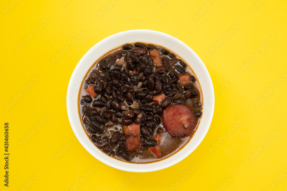 black beans with meat and sausages in white bowl black beans with meat and sausages in white bowl