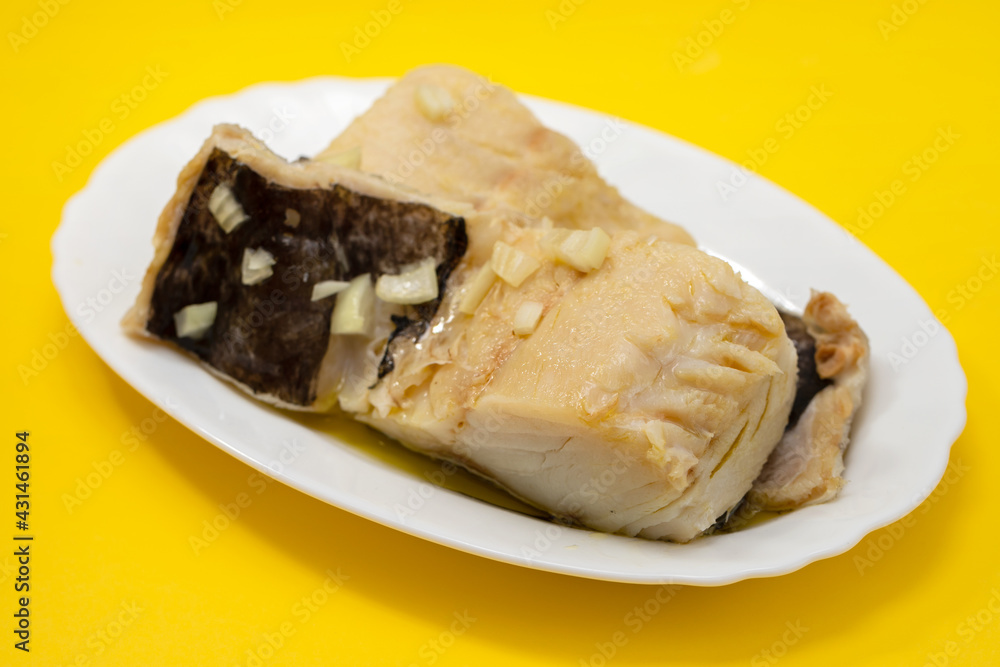boiled cod fish with olive oil on white dish