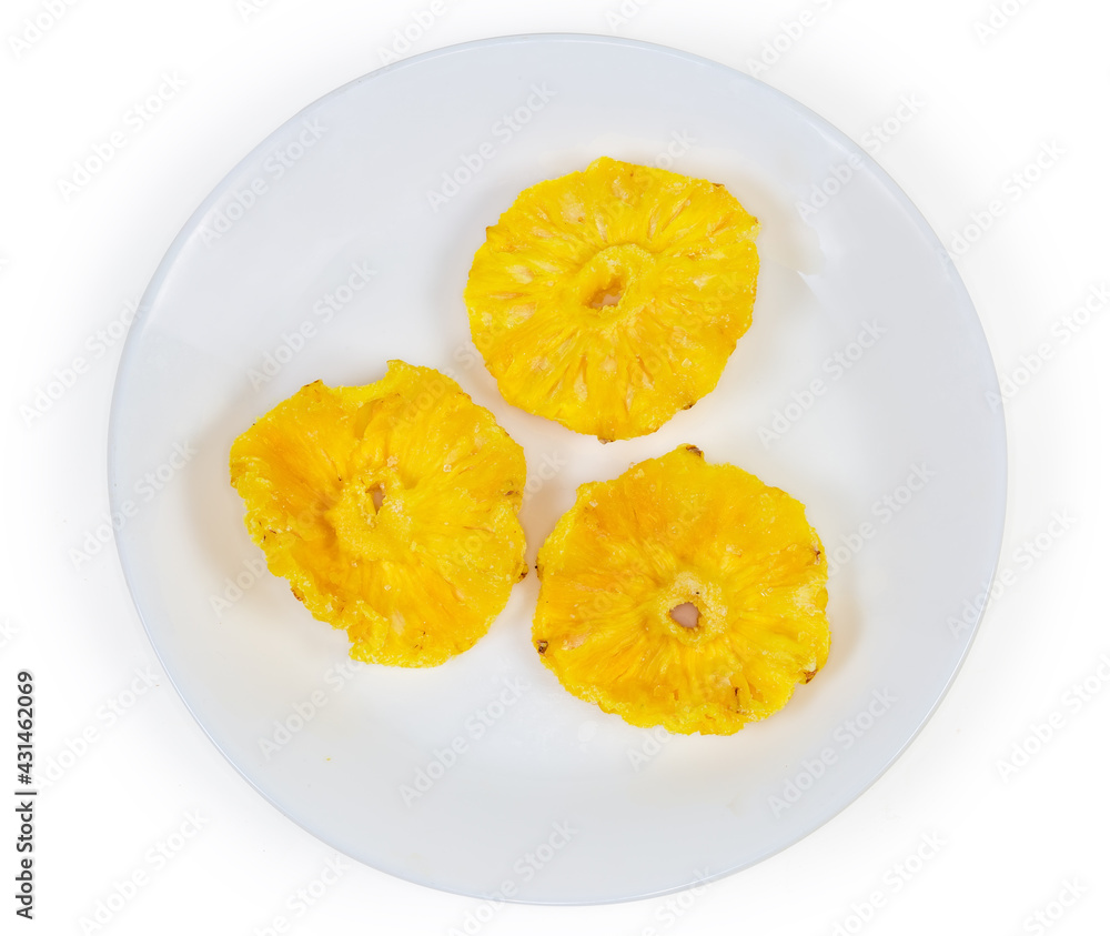 Top view of dried pineapples slices on white dish Top view of dried pineapples slices on white dish