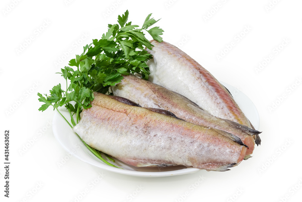 Defrosted uncooked carcasses of Alaska pollock with parsley on dish Defrosted uncooked carcasses of Alaska pollock with parsley on dish