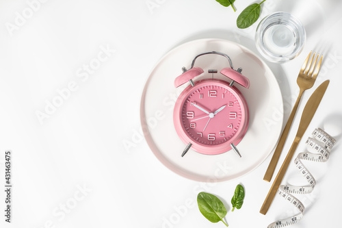 Composition with cutlery, measuring tape and alarm clock on color background. Diet concept, copy space photo