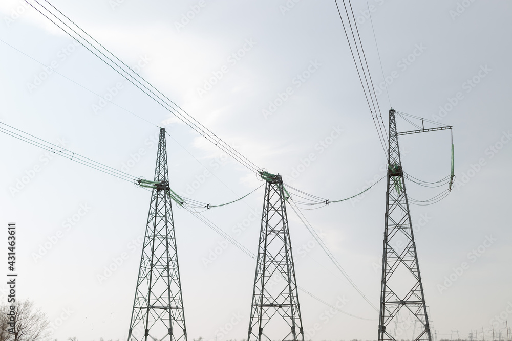 Electric poles in the fields during the daytime. Transportation of alternative and renewable electricity. Electric poles in the fields during the daytime. Transportation of alternative and renewable electricity.