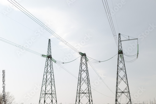 Electric poles in the fields during the daytime. Transportation of alternative and renewable electricity.