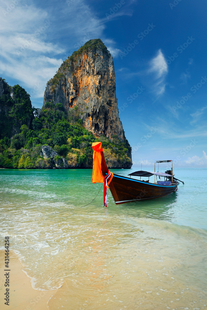 Obraz premium long tail boat, in white sand beach in andaman sea with view of limestone island 