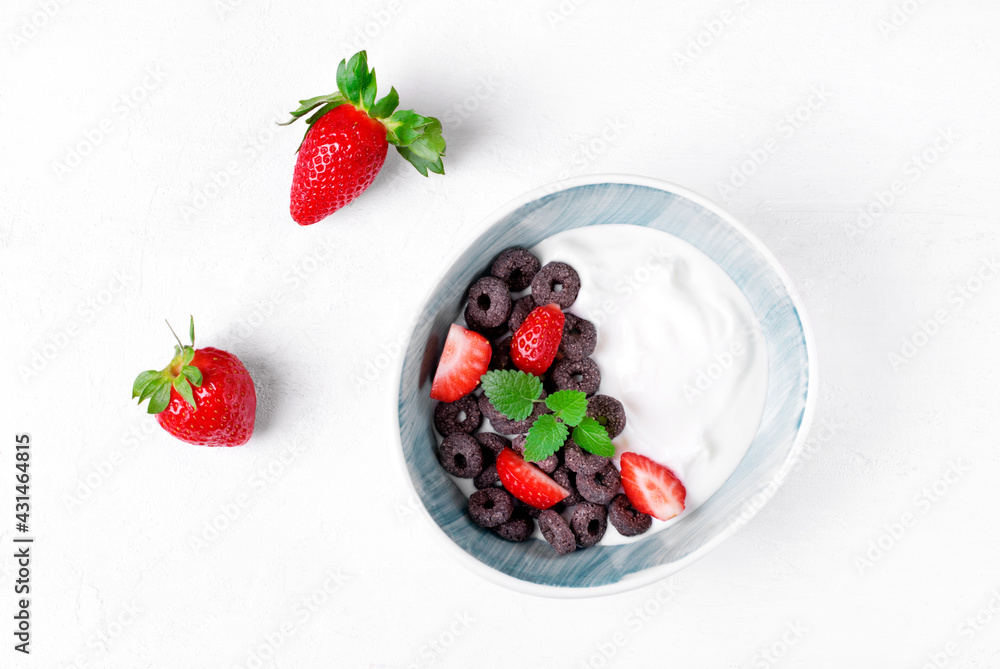 Yogurt with black cereals and strawberry served in the bowl. Top view. Breakfast meal Yogurt with black cereals and strawberry served in the bowl. Top view. Breakfast meal