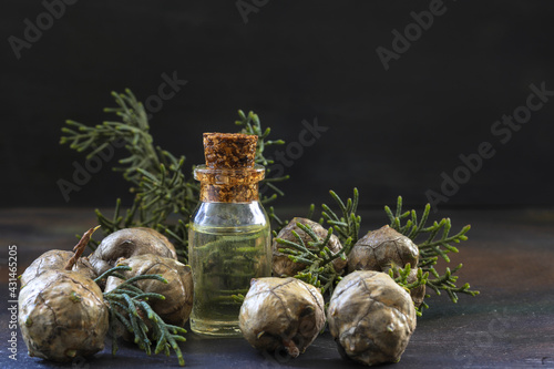 Pine cones and a bottle of pine essential oil on a wooden table
