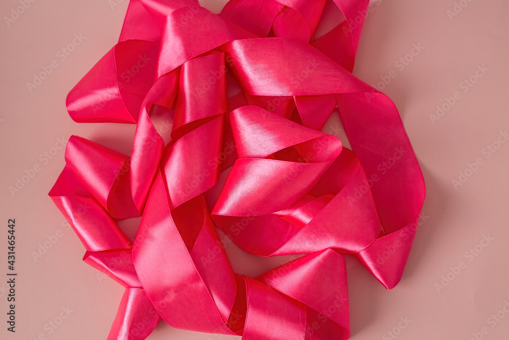 Pink satin ribbon for gift wrapping on a pink background. Pink satin ribbon for gift wrapping on a pink background.
