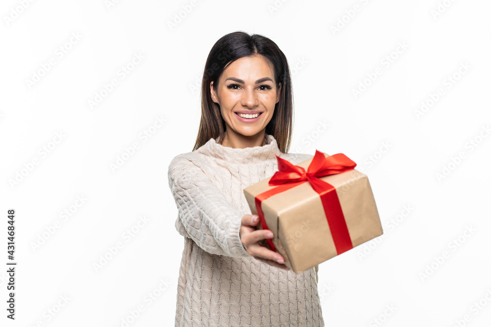 Portrait of a happy woman holding present box while standing and looking at camera isolated over white background Portrait of a happy woman holding present box while standing and looking at camera isolated over white background
