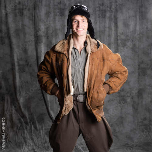 Happy smiling aviator pilot in retro style, a young man in a flight jacket