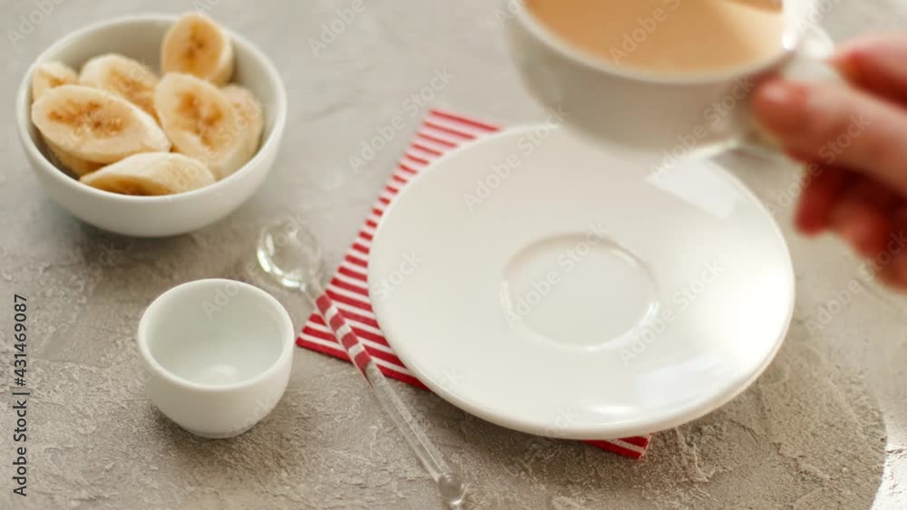 Cup of coffee with milk on a grey concrete texture table. Female hand takes a cup of hot drink. Healthy breakfast concept Cup of coffee with milk on a grey concrete texture table. Female hand takes a cup of hot drink. Healthy breakfast concept