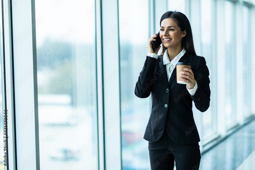Businesswoman with coffee and talking on the phone near office Businesswoman with coffee and talking on the phone near office