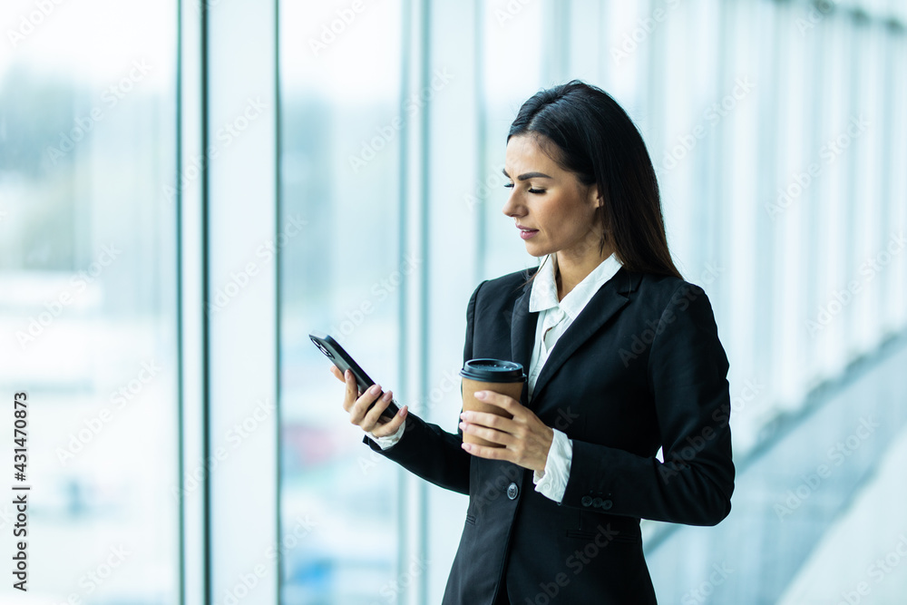 Obraz premium Young business woman use phone for text or surfing in internet in modern office.