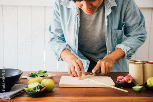 people are slicing lemongrass he is looking to recipes in the kitchen. reading cooking books of the food menu, salad canned fish cook. quarantine at home concept