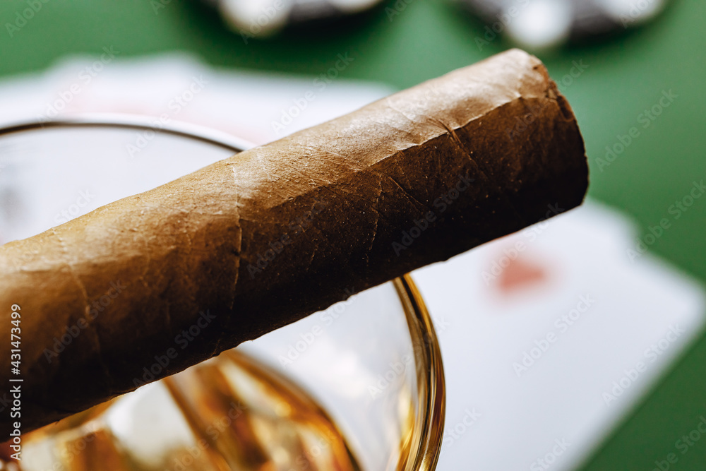 Close up of whiskey glass and cigar on green background - obrazy, fototapety, plakaty 
