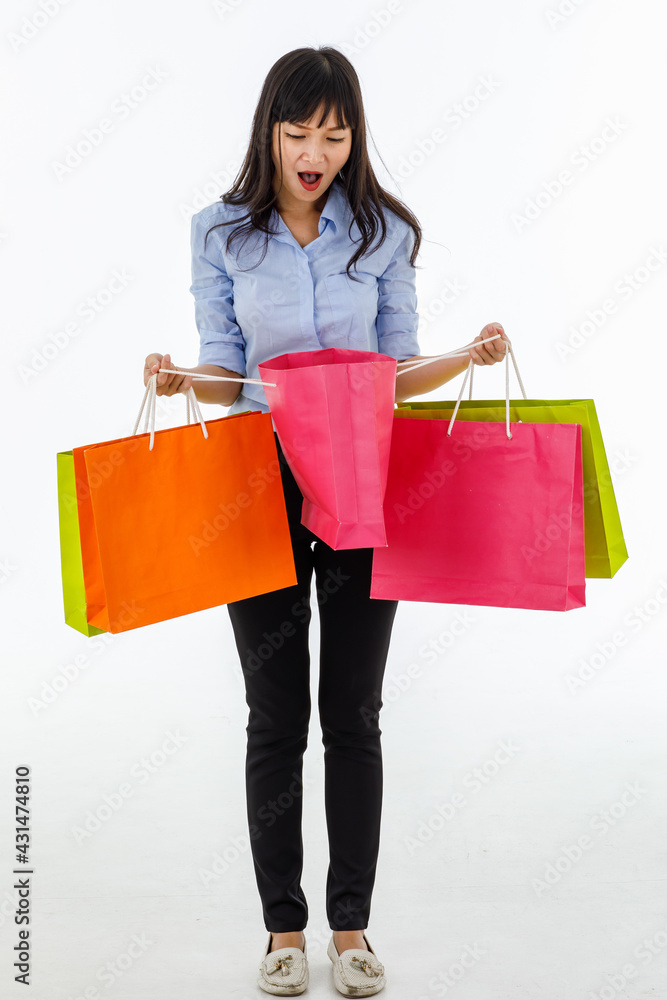 Woman standing with a multicolored shopping bags in her hand. Open pink one and scream wow with joy in a beautiful, affordable, happy price.