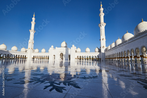 The court of Sheikh Zayed Mosque with two minarets reflected on the marbe ground, UAE, Abu Dhabi
