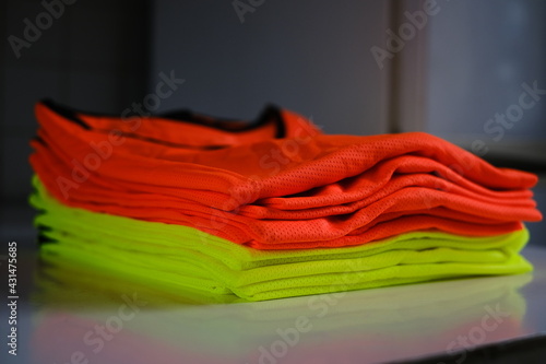 a stack of red and green coaching football shirts