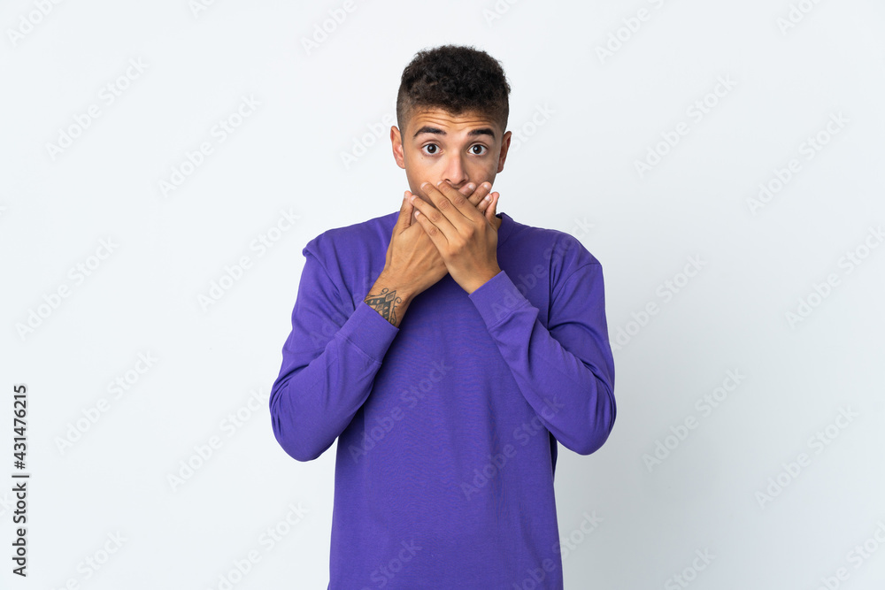 Young brazilian man isolated on white background covering mouth with hands Young brazilian man isolated on white background covering mouth with hands