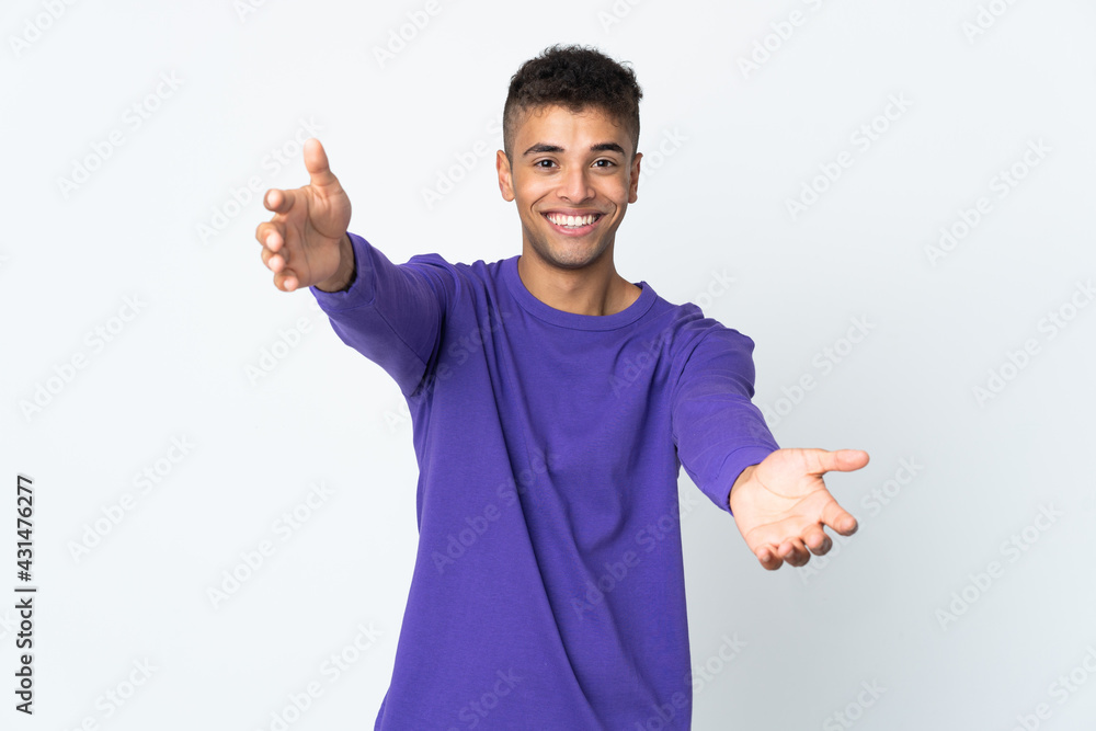 Young brazilian man isolated on white background presenting and inviting to come with hand Young brazilian man isolated on white background presenting and inviting to come with hand