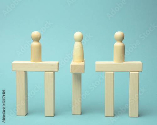 little wooden men stand on the destroyed bridge on different sides on a blue background. photo