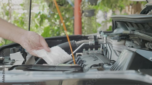 Closeup of man check engine oil level of his car at home by myself. Maintain, check prepare for the trip