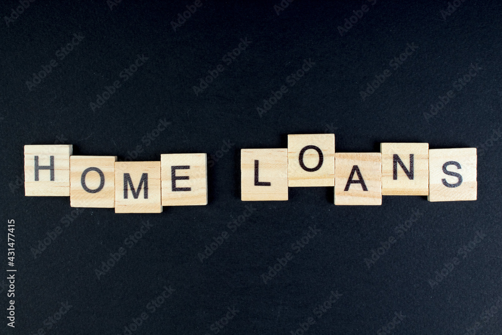 Obraz premium HOME LOAN - word composed fromwooden blocks letters on black background, copy space for ad text.