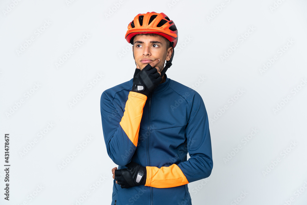 Young cyclist Brazilian man isolated on white background having doubts