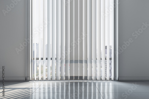 Light wall with blinds on windows in sunny empty office room