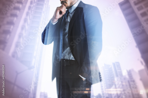 Businessman standing thinking with skyscrapers in the background, decision and entrepreneurship concept. Double exposure