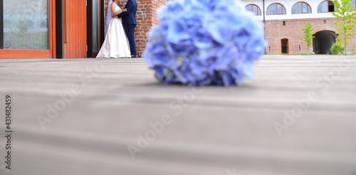 Photo bride and groom together holding a blue flower bouquet